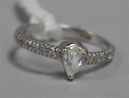 A modern 14ct white gold and pear shaped single stone diamond ring, with diamond set shoulders, size L.